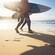 2 surfers carrying their boards into the surf at Bondi Beach in Sydney, Australia